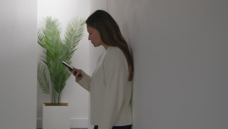 Stressed-Or-Anxious-Woman-Leaning-Against-Wall-At-Home-Reacting-To-Internet-Or-Social-Media-News-Message-Or-Story-On-Mobile-Phone-2